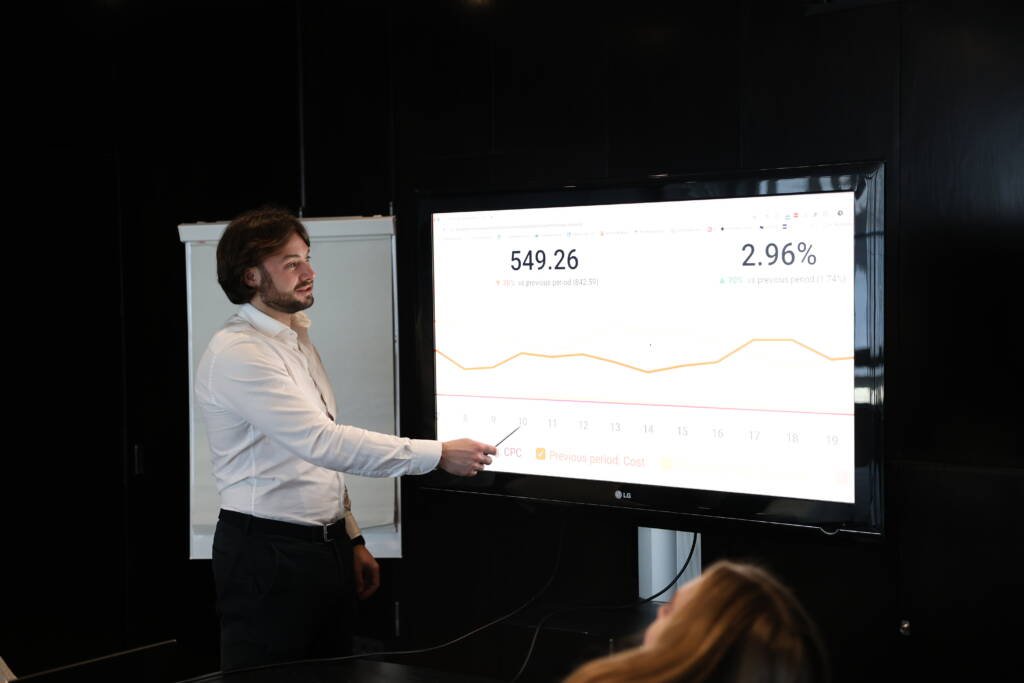 Man presenteert resultaten en wijst met pen op scherm