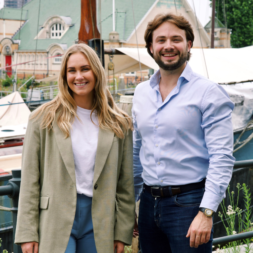 man en vrouw werkzaam voor een digital agency staand voor een klein haventje