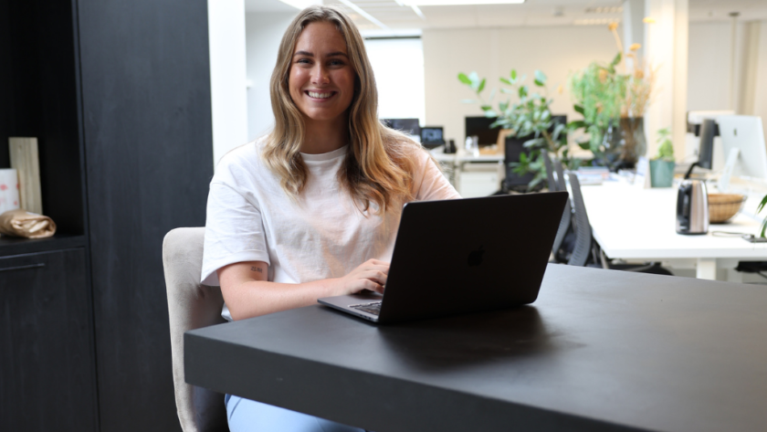 Maxime achter haar laptop aan het werk met AI-vastgoedmarketing