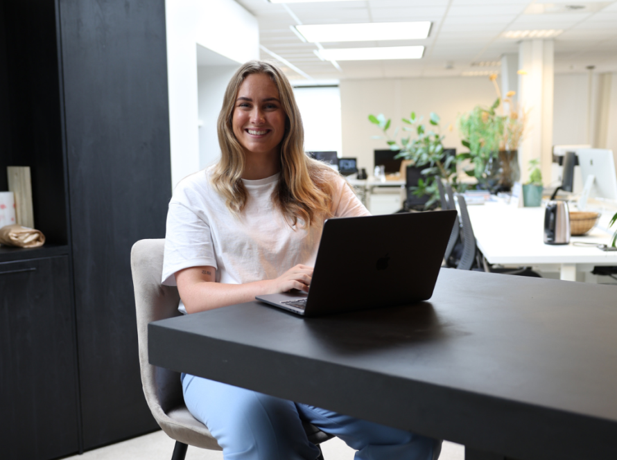 Maxime achter haar laptop aan het werk met AI-vastgoedmarketing